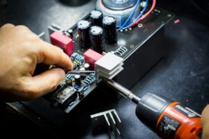 Technician inspecting an industrial control panel as part of a predictive maintenance strategy to improve equipment reliability.